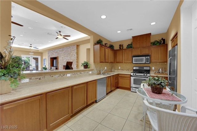 kitchen with appliances with stainless steel finishes, light countertops, and a sink