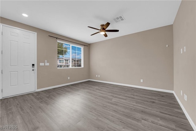 interior space with baseboards, ceiling fan, visible vents, and wood finished floors