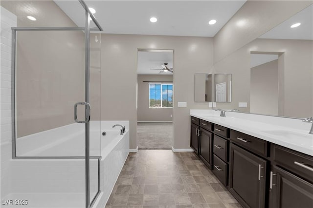 bathroom featuring a stall shower, double vanity, a sink, and a bath