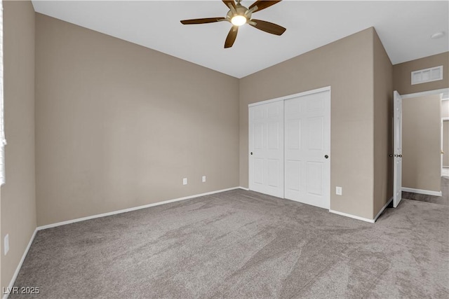 unfurnished bedroom featuring a closet, visible vents, a ceiling fan, carpet flooring, and baseboards