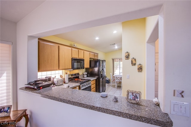 kitchen with visible vents, vaulted ceiling, light brown cabinetry, black appliances, and recessed lighting