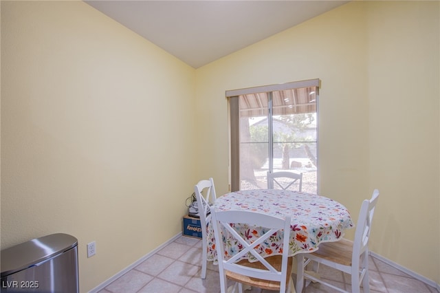 dining room with lofted ceiling and baseboards