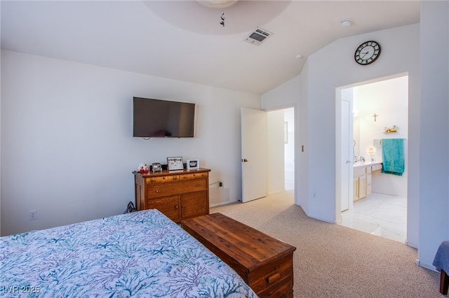 bedroom with lofted ceiling, visible vents, connected bathroom, and light colored carpet