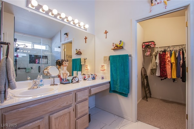 bathroom with vanity, baseboards, marble finish floor, a spacious closet, and a stall shower