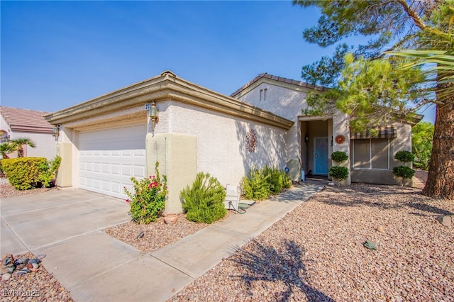 view of front of house featuring a garage, driveway, and stucco siding