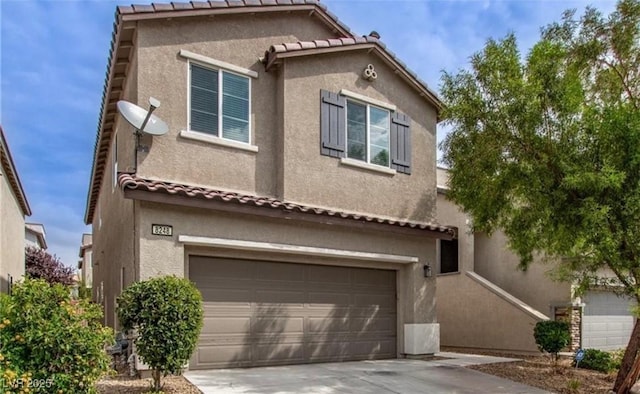 view of front of property featuring a garage, a tile roof, concrete driveway, and stucco siding