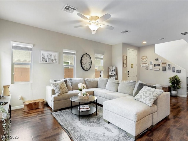 living area with dark wood-type flooring, visible vents, and baseboards