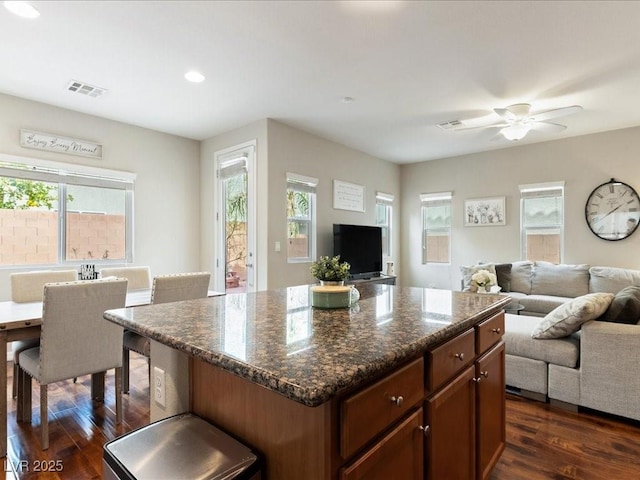 kitchen featuring visible vents, open floor plan, dark wood-type flooring, and a center island