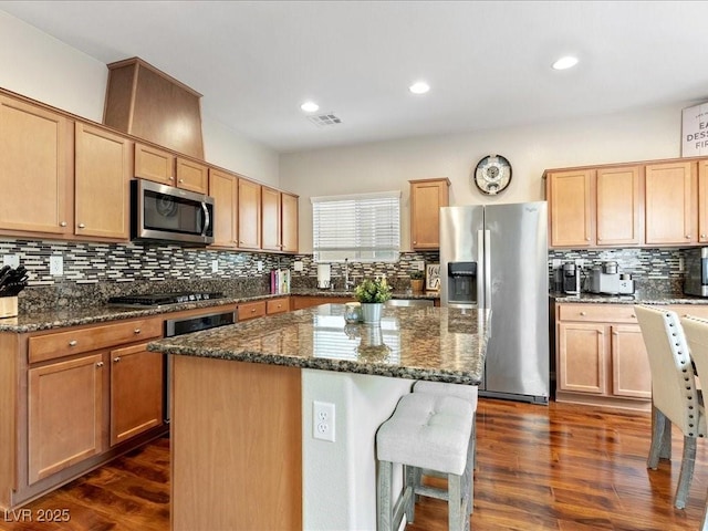 kitchen featuring stainless steel appliances, dark wood-type flooring, visible vents, and decorative backsplash