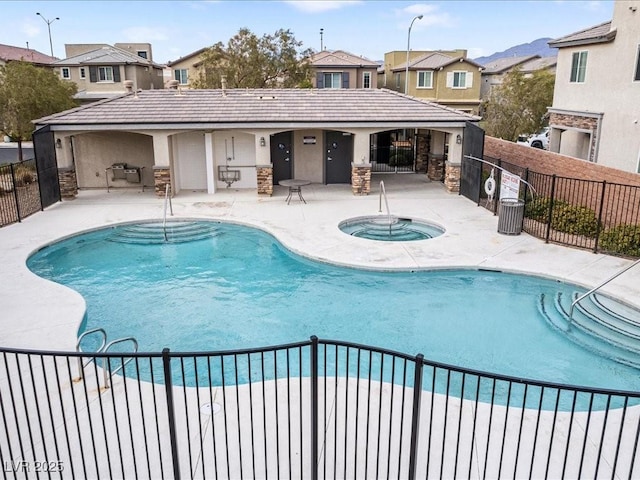 community pool with a community hot tub, a patio area, and fence