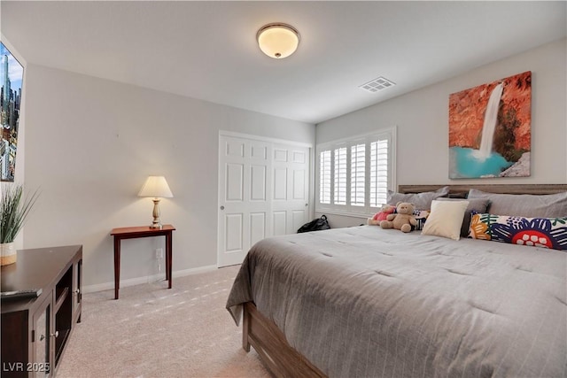 bedroom with baseboards, a closet, visible vents, and light colored carpet