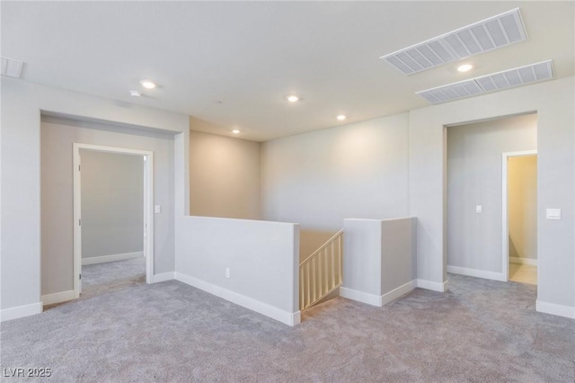 carpeted empty room featuring recessed lighting, visible vents, and baseboards