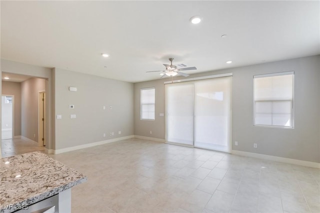 interior space with a ceiling fan, recessed lighting, and baseboards