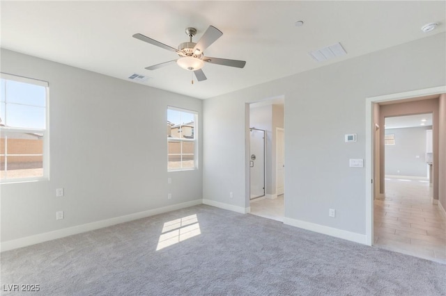 unfurnished bedroom with baseboards, visible vents, a ceiling fan, and light colored carpet