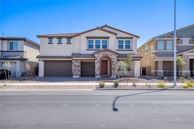 view of front of property with an attached garage, stone siding, a tile roof, and stucco siding