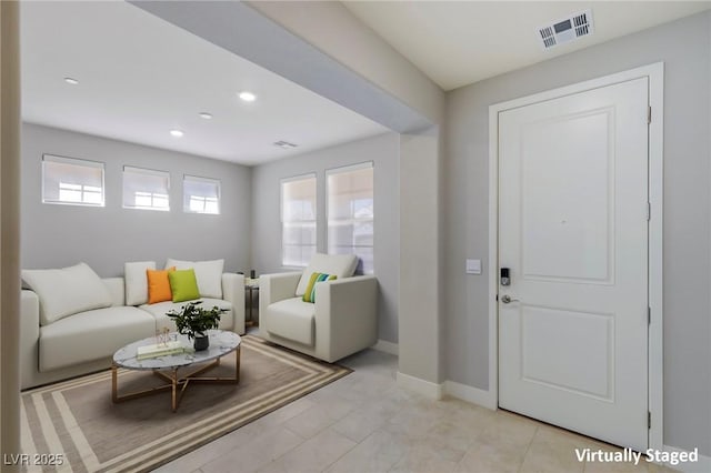 living room with recessed lighting, visible vents, and baseboards