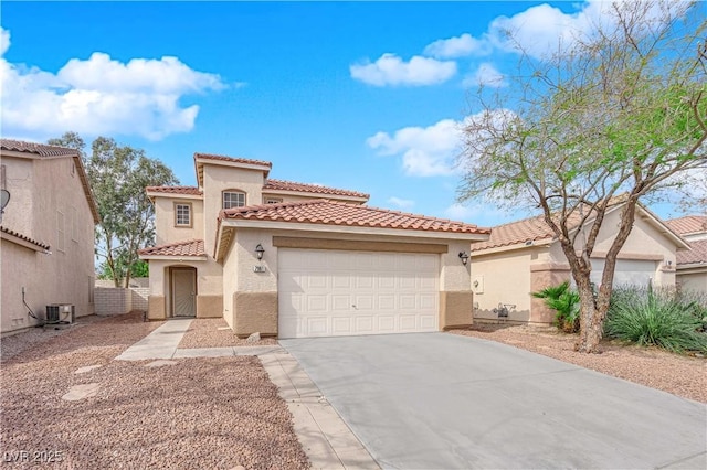 mediterranean / spanish-style house with an attached garage, driveway, a tile roof, and stucco siding