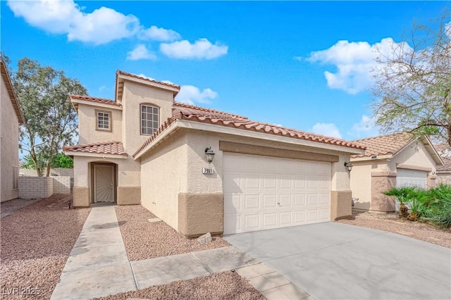 mediterranean / spanish home featuring a tile roof, stucco siding, fence, a garage, and driveway