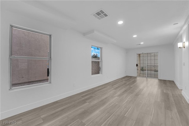 spare room featuring light wood finished floors, baseboards, visible vents, and recessed lighting