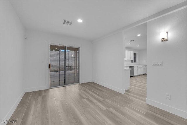 spare room with light wood finished floors, baseboards, visible vents, and recessed lighting