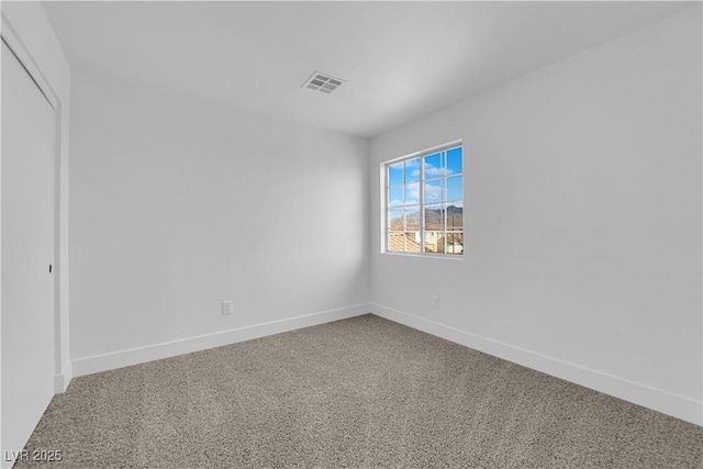 carpeted empty room featuring visible vents and baseboards