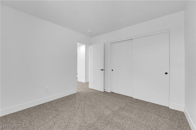 unfurnished bedroom featuring a closet, carpet flooring, and baseboards