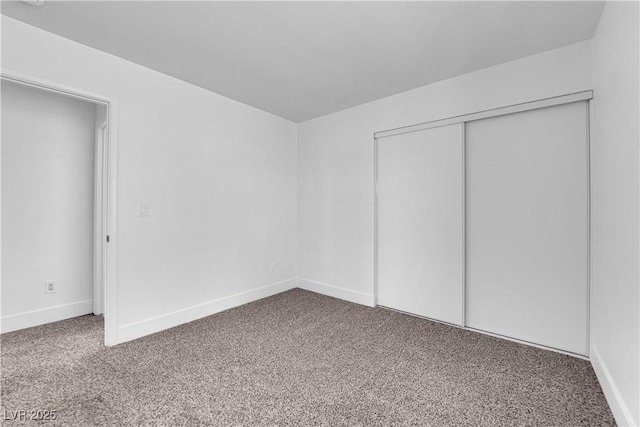 unfurnished bedroom featuring carpet, a closet, and baseboards