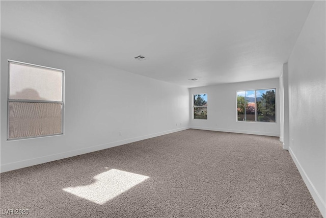 carpeted empty room with visible vents and baseboards