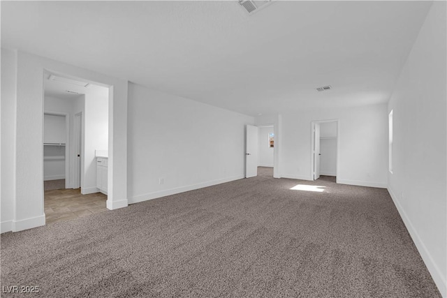 interior space featuring carpet floors, baseboards, and visible vents