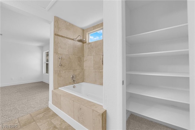 bathroom with tiled shower / bath combo and baseboards