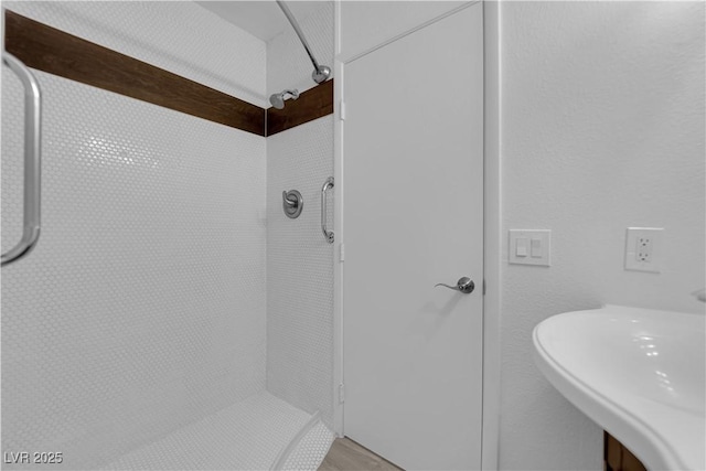 bathroom with a sink and tiled shower