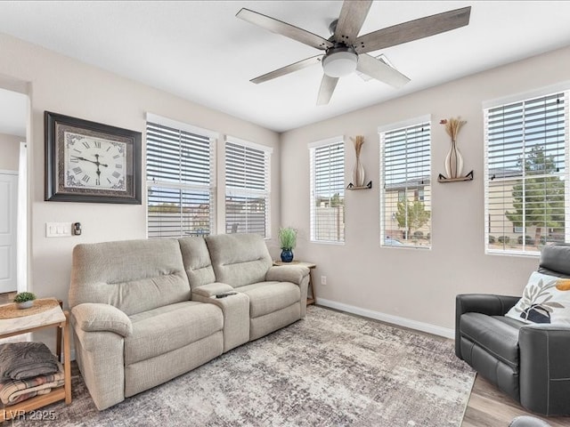 living room with wood finished floors, a ceiling fan, and baseboards