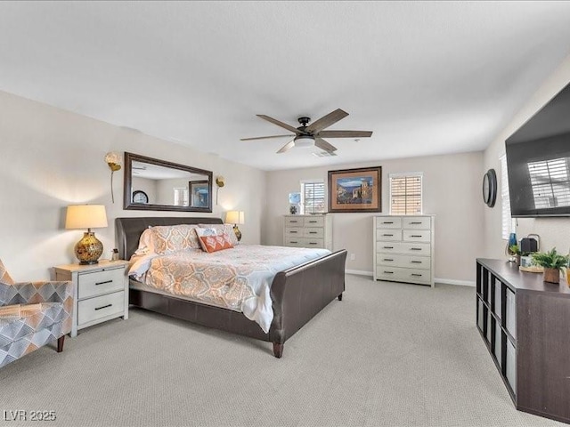 bedroom with light colored carpet, baseboards, and a ceiling fan