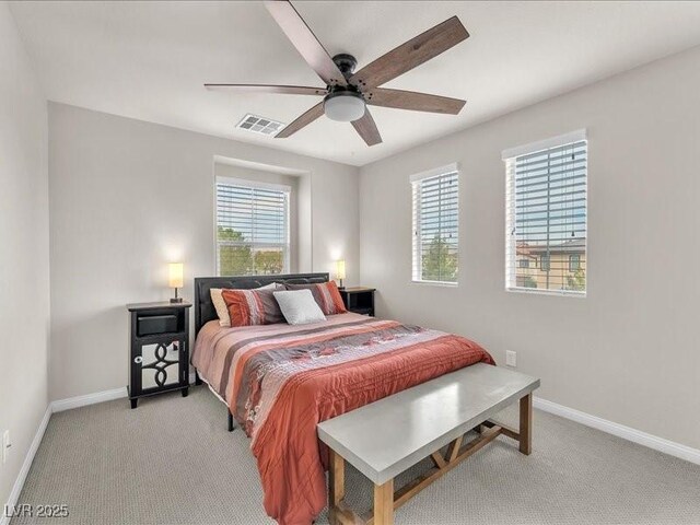 bedroom with light carpet, multiple windows, and baseboards