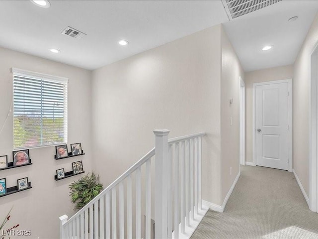 hall with recessed lighting, an upstairs landing, visible vents, and baseboards