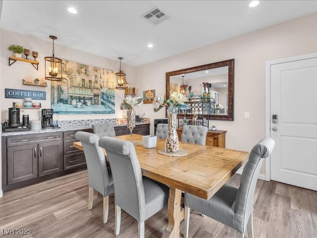 dining area with light wood finished floors, visible vents, and recessed lighting