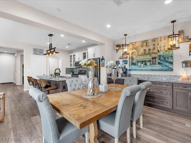 dining space featuring recessed lighting and light wood-style floors