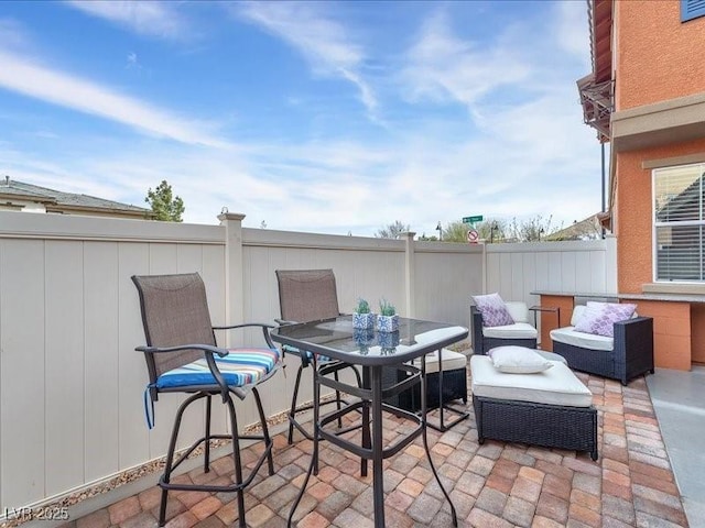 view of patio featuring outdoor dining space and fence