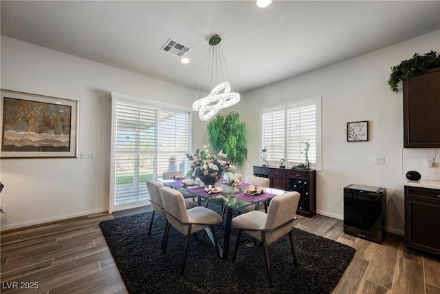 dining room featuring a notable chandelier, recessed lighting, visible vents, wood finished floors, and baseboards