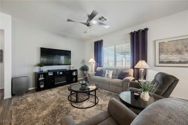 living area with ceiling fan, visible vents, and baseboards