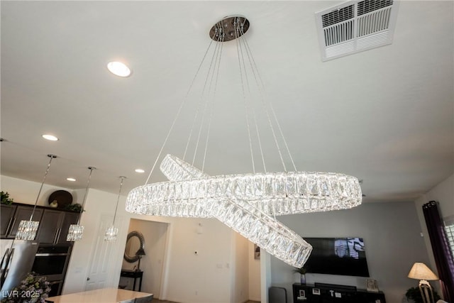 interior details featuring recessed lighting, stainless steel oven, visible vents, dark brown cabinets, and hanging light fixtures