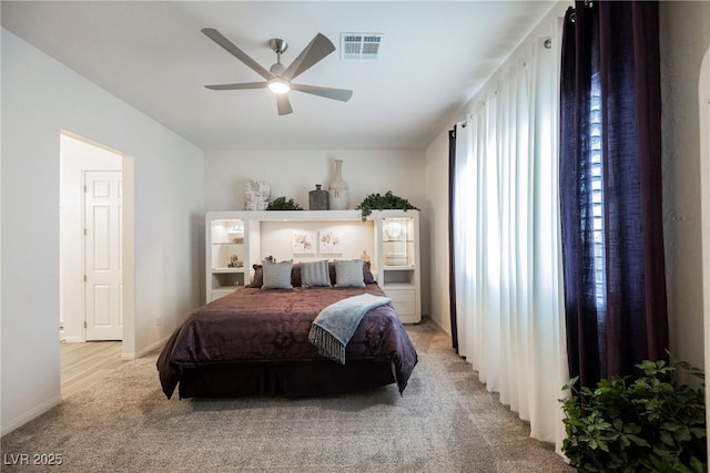 bedroom featuring baseboards, visible vents, a ceiling fan, and light colored carpet