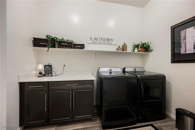 laundry room with wood finish floors, cabinet space, independent washer and dryer, and baseboards