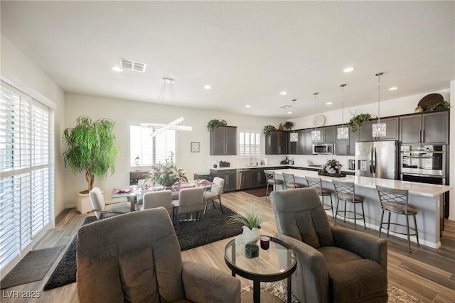 dining space featuring wood finished floors, visible vents, and recessed lighting