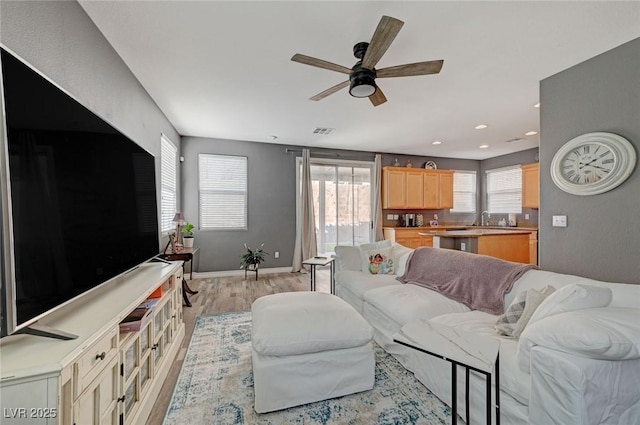 living room with ceiling fan, light wood-style flooring, recessed lighting, visible vents, and baseboards