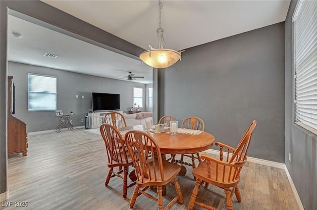 dining area with light wood finished floors, plenty of natural light, and baseboards