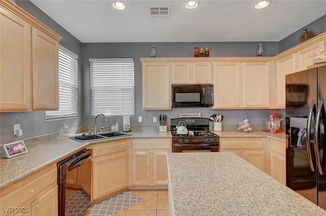 kitchen with a sink, black appliances, and light brown cabinetry