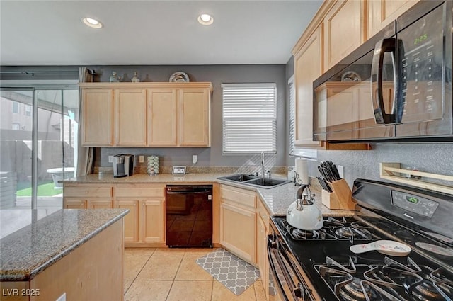 kitchen with light tile patterned flooring, a sink, black appliances, and light brown cabinetry