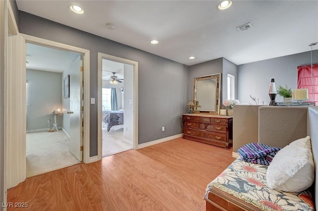 sitting room with light wood-type flooring, visible vents, baseboards, and recessed lighting