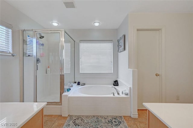 bathroom with a garden tub, a shower stall, visible vents, and vanity